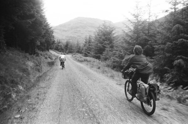 Two cyclists on a forest track — black and white film photography © Ruskin Brown